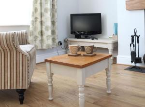 een woonkamer met een tafel met twee kopjes erop bij Pickles Cottage in Barnoldswick
