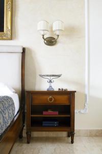 a night stand with a lamp on top of a bed at Grand Hotel President in Olbia