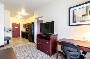 a hotel room with a desk with a computer and a television at Cobblestone Hotel & Suites - McCook in McCook