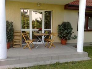 a patio with chairs and a table in front of a house at Aparthouse in Wrocław