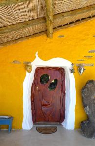 una puerta con una cara pintada en el lateral de un edificio en The Hobbit House - Montes da Ronha en Odemira