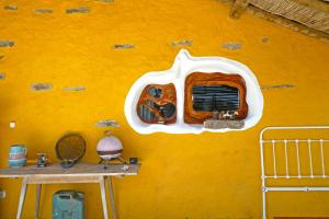 a yellow wall with a window in a room at The Hobbit House - Montes da Ronha in Odemira