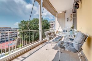 a balcony with chairs and a table and a large window at Bella Venezia Residence in Corfu Town