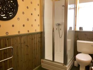 a bathroom with a toilet and a glass shower at The Sunningdale in Skegness