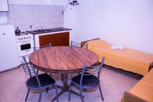 a kitchen with a table and chairs and a bed at Departamentos 27 in San Clemente del Tuyú