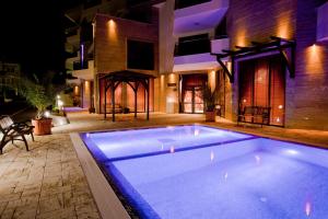a swimming pool in front of a house at night at Millennium Apart Complex in Sveti Vlas