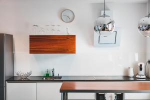 a kitchen with a table and a clock on the wall at O-Apartment in Obernburg am Main