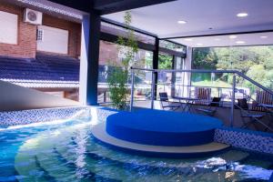 an indoor pool with a table and chairs in a building at San Remo New Viking in Pinamar
