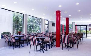 un ristorante con tavoli, sedie e colonne rosse di San Remo New Viking a Pinamar