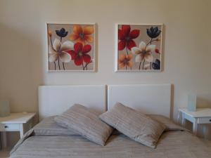 1 dormitorio con 3 pinturas en la pared sobre una cama en Il Sorriso, en Florencia