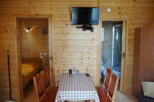 comedor con mesa y TV en una cabina en Domek 100 m od morza, en Jastarnia