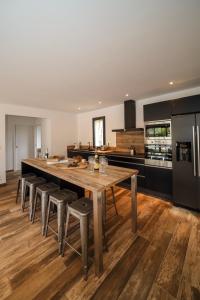 a large kitchen with a large wooden table and stools at Hôtel confidentiel Le Grecale in Pianottoli-Caldarello