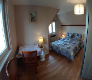 1 dormitorio con 1 cama, mesa y sillas en LA MAISON FLEURIE Gîtes du Florimont, en Ingersheim