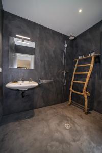 a bathroom with a sink and a mirror and a ladder at Hôtel confidentiel Le Grecale in Pianottoli-Caldarello