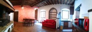 a living room with a red couch in a building at Il Papavero - Montefioralle Apartment in Greve in Chianti