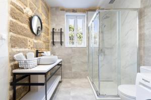 a bathroom with a glass shower and a sink at A33 Rhodes Old Town House in Rhodes Town