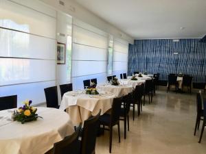 a row of tables in a room with white table cloths at Hotel La Meridiana in Sorrento