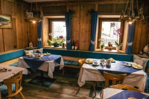um restaurante com duas mesas e duas janelas em Landhaus Summerer em Sesto