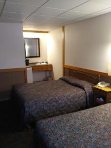 um quarto de hotel com duas camas e uma televisão em Algoma Motel em Wawa