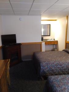 a hotel room with two beds and a desk at Algoma Motel in Wawa