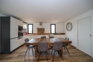 a kitchen and dining room with a wooden table and chairs at Hôtel confidentiel Le Grecale in Pianottoli-Caldarello