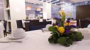 a white table with a vase of flowers on it at Hotel La Meridiana in Sorrento