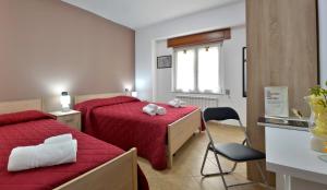 um quarto com duas camas e uma cadeira em Mastro Gio em San Giovanni in Fiore