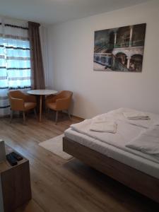 una camera da letto con un letto, un tavolo e delle sedie di Focus Home a Miercurea-Ciuc Altre 4 foto