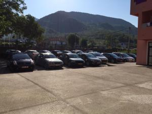 una fila de autos estacionados en un estacionamiento en Guesthouse Orlović, en Budva