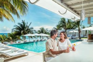 プラヤ・デル・カルメンにあるBlue Diamond Luxury Boutique - All Inclusive Adults Onlyのリゾートのプールサイドのテーブルに座っているカップル +123枚の写真