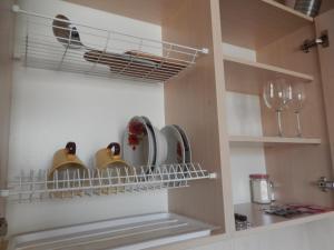 a kitchen cabinet with plates and wine glasses at Studio Darvina 20 in Kharkiv