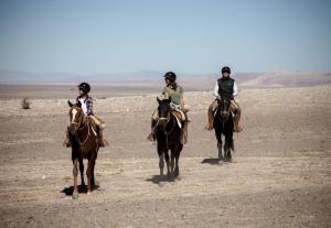a group of people riding horses in the desert at Explora en Atacama - All Inclusive in San Pedro de Atacama