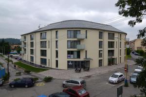 un gran edificio con coches estacionados en un estacionamiento en Hotel Bélier, en Prešov