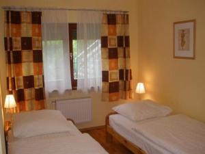 2 camas individuales en una habitación con ventana en Aparthouse, en Wroclaw