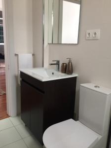 een badkamer met een witte wastafel en een toilet bij Retiro dos Reis in Horta +32 foto's