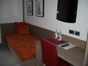 a room with a bed and a table with a tv at Dolomiti Lodge Villa Gaia in Venas