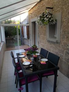 uma mesa preta com cadeiras e flores num pátio em Gite Gabrielle em Saint-Jean-dʼAlcapiès