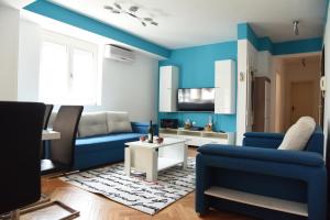a living room with blue walls and a blue couch at Kiara Apartments Skopje in Skopje