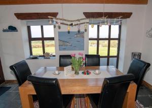 een eetkamer met een houten tafel en stoelen bij Dunmanus View in Durrus