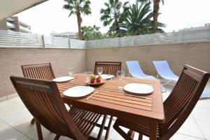 Une table et des chaises en bois sont disponibles sur la terrasse. dans l'établissement Saval Spa Aqquaria Family Complex, à Salou