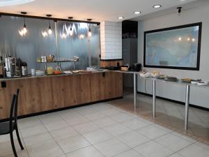 a restaurant with a counter with food on it at Hotel Romanville in Chapecó