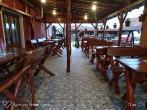 an empty restaurant with wooden tables and chairs at Casa Suzy & Roxy in Arpaşu de Jos