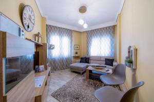 a living room with a couch and a clock on the wall at Kentrikon deluxe Apt.(must) in Thessaloniki
