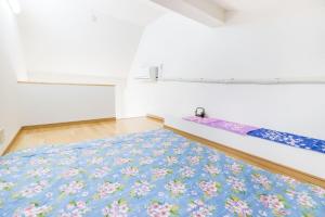 Zimmer mit einem Bett mit einem blauen und rosa Teppich in der Unterkunft Haneda Airport Apartment in Tokio