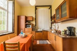 a kitchen with a table and a kitchen with a counter top at Casa Dos Barcos Furnas in Furnas