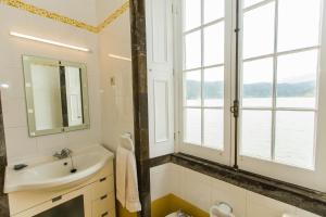 a bathroom with a sink and a mirror and windows at Casa Dos Barcos Furnas in Furnas