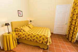 a bedroom with a bed with a yellow bedspread at Casa Dos Barcos Furnas in Furnas