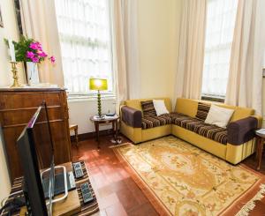 a living room with a couch and a tv at Casa Dos Barcos Furnas in Furnas