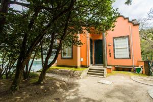 an orange house with trees in front of it at Casa Dos Barcos Furnas in Furnas