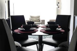 Una mesa con cuatro tazas y platillos. en Royal Stays Furnished Apartments - Missisauga City Centre, en Mississauga